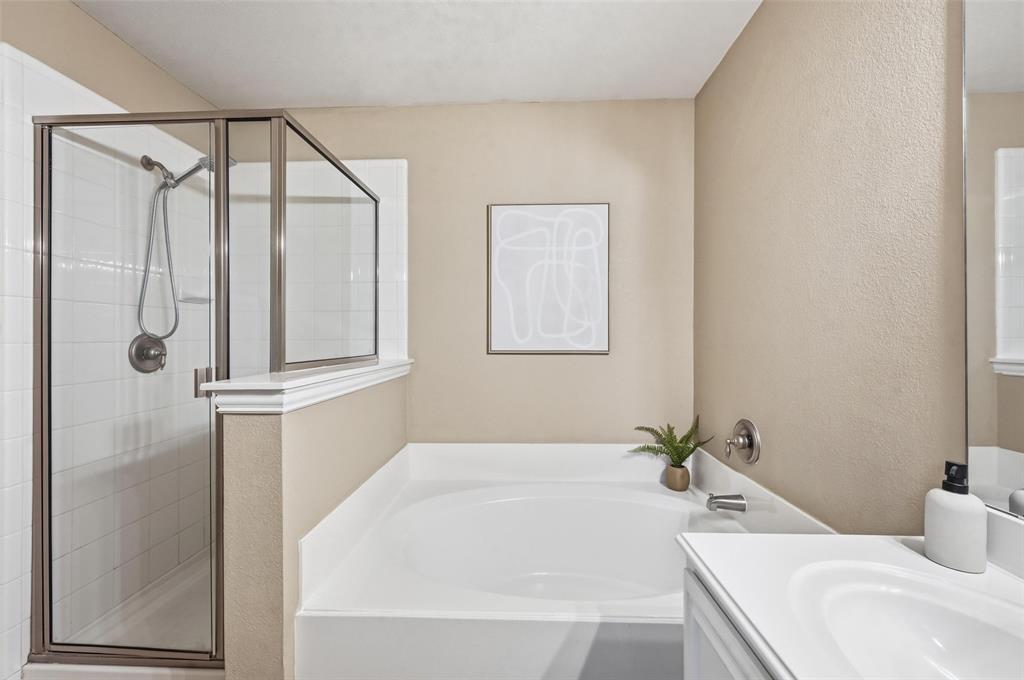 2522 Durango Ridge Drive Bedford, TX 76021 - Photo 24 of 35 Bathroom featuring a bath, vanity, a shower stall, and a textured wall