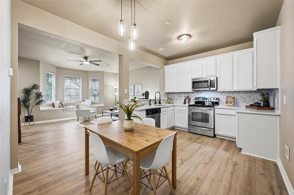 2522 Durango Ridge Drive Bedford, TX 76021 - Photo 7 of 35 Kitchen featuring white cabinets, stainless steel appliances, pendant lighting, decorative backsplash, and light wood finished floors