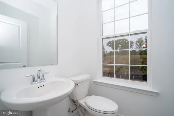 a bathroom with a sink a toilet and a window
