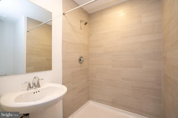 a bathroom with a sink a shower and a mirror