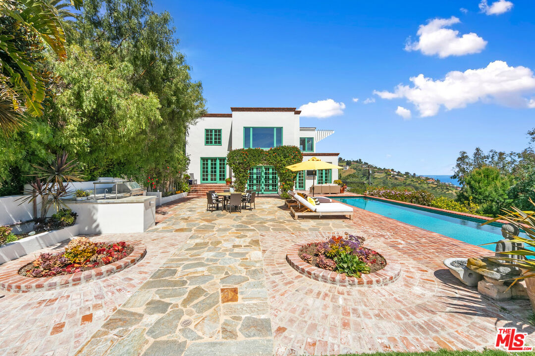 22355 Carbon Mesa Road Malibu, CA 90265 - Photo 21 of 69 a view of a swimming pool with lounge chairs