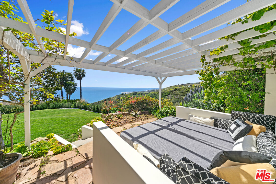 22355 Carbon Mesa Road Malibu, CA 90265 - Photo 61 of 69 a view of a patio with a table and chairs under an umbrella
