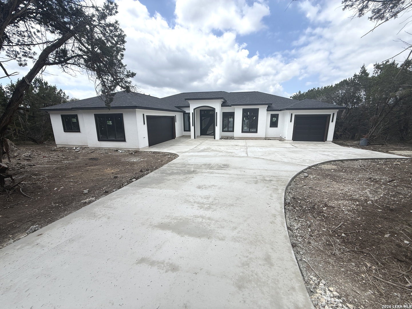 a front view of a house with yard and trees