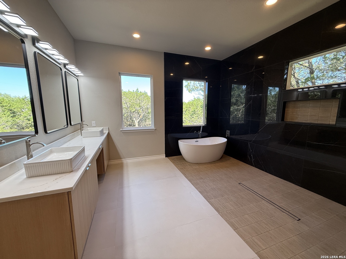 189 Mustang Lane Spring Branch, TX 78070 - Photo 32 of 53 a spacious bathroom with a double vanity sink a mirror and a bathtub