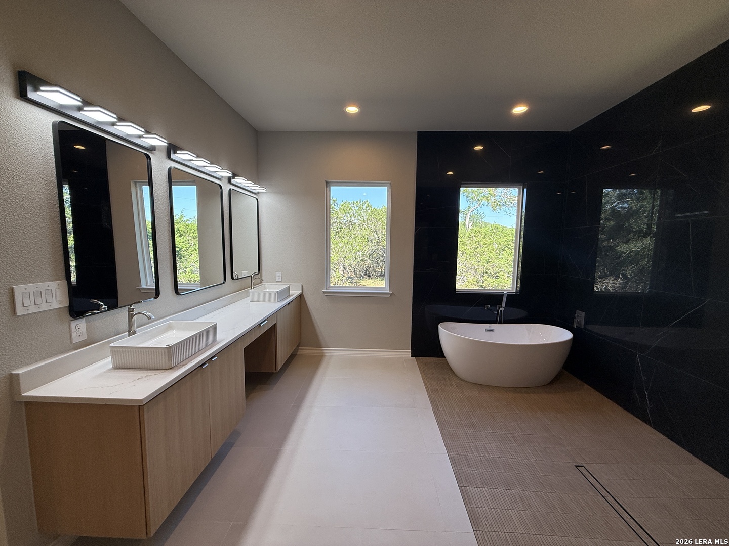 189 Mustang Lane Spring Branch, TX 78070 - Photo 36 of 53 a large spacious bathroom with double vanity sinks a large mirror and a bathtub