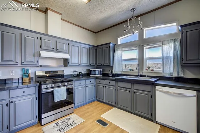 a large kitchen with stainless steel appliances lots of wooden cabinets a sink and dishwasher