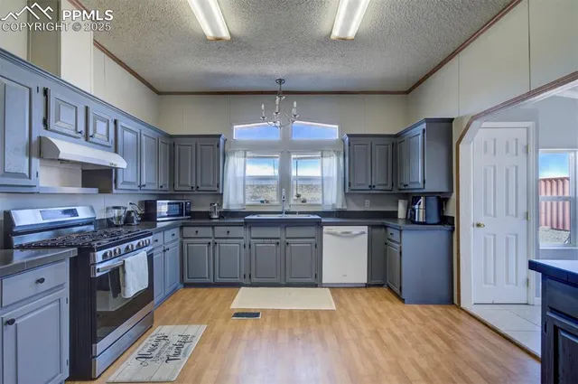 a large kitchen with stainless steel appliances granite countertop a stove sink and cabinets