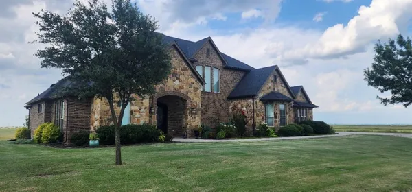 a view of a big house with a big yard and large trees