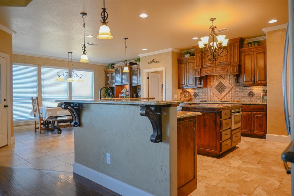 1397 Cr 338 Gainesville Tx 76240 Gainesville, TX 76240 - Photo 6 of 36 a kitchen with stainless steel appliances kitchen island granite countertop a refrigerator a stove and a sink with chandelier