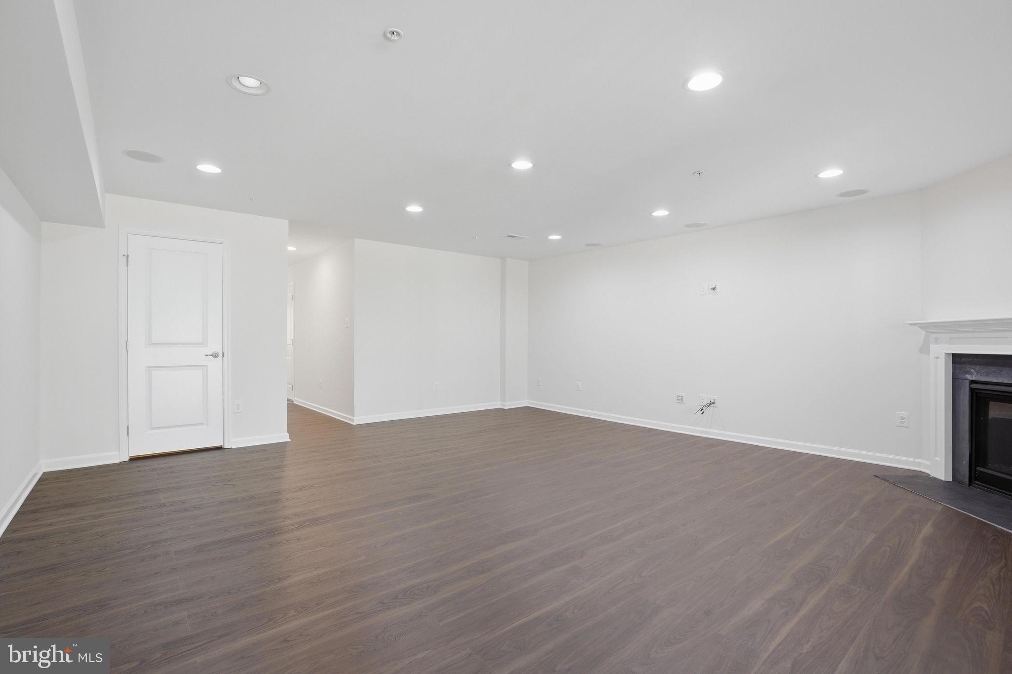 2784 Fredericksburg Road Hanover, MD 21076 - Photo 12 of 60 a view of an empty room with wooden floor and a fireplace