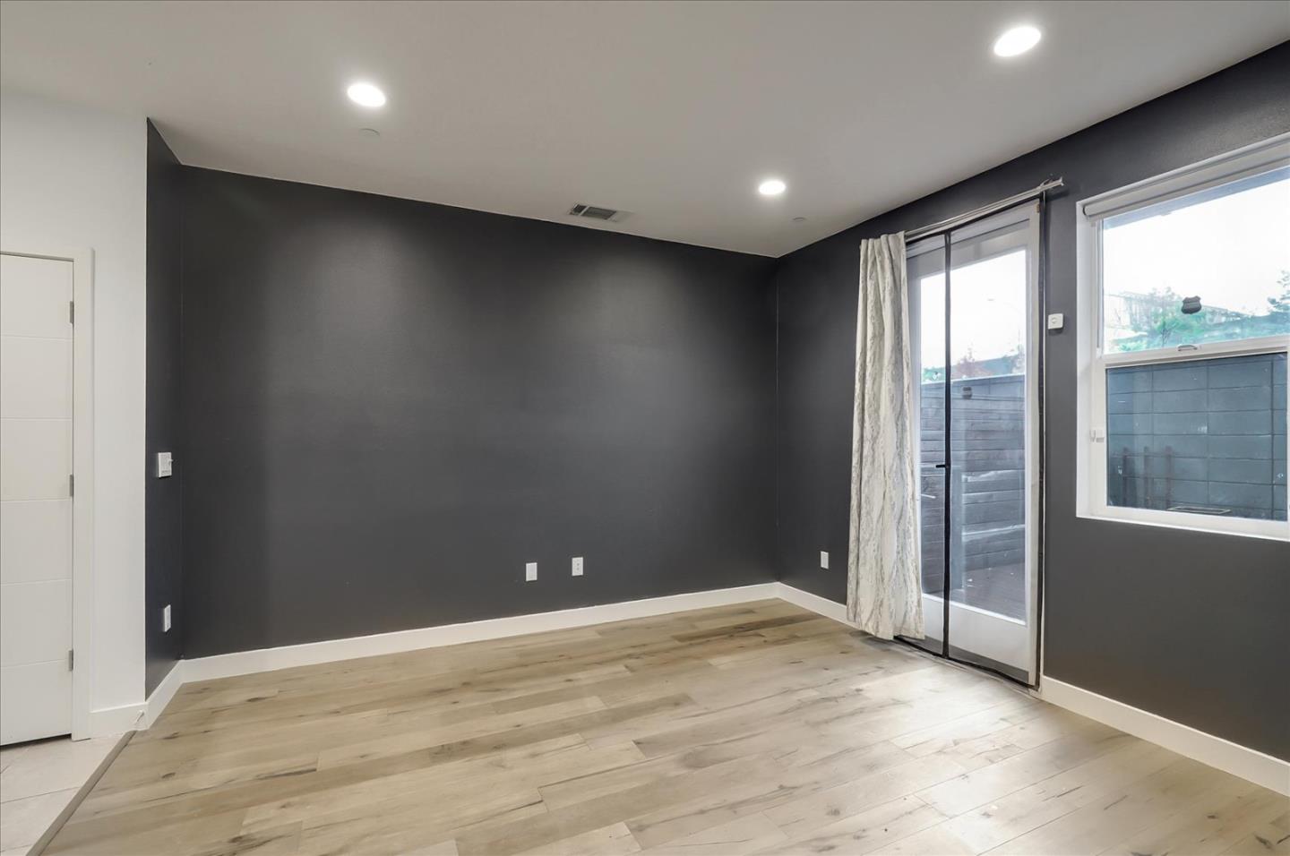 1405 Pullman Way Oakland, CA 94607 - Photo 11 of 36 an empty room with wooden floor and windows