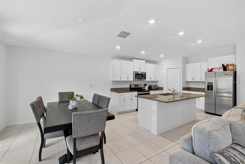 1748 Red Loop Lakeland, FL 33801 - Photo 16 of 66 a kitchen with stainless steel appliances kitchen island granite countertop a dining table chairs and a refrigerator