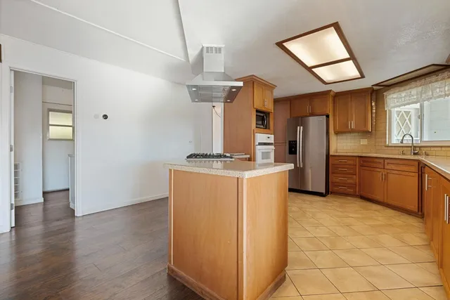 a kitchen with stainless steel appliances granite countertop a refrigerator and a sink