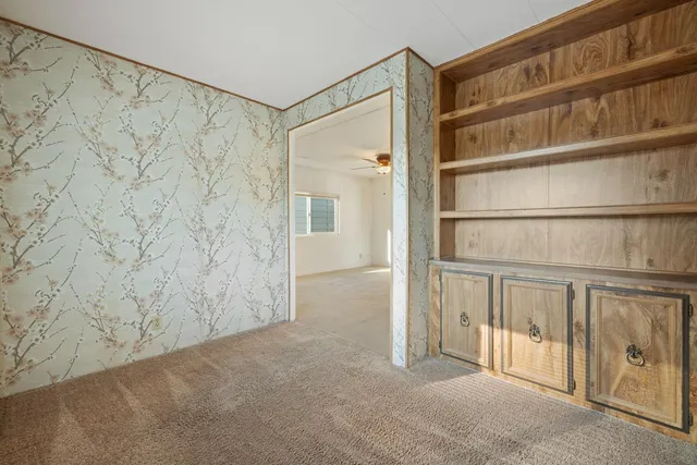 an empty room with closet and a ceiling fan