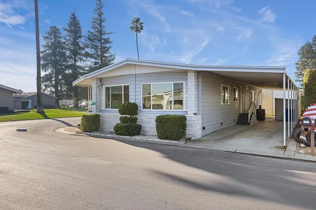 a front view of a house with a garden and plants