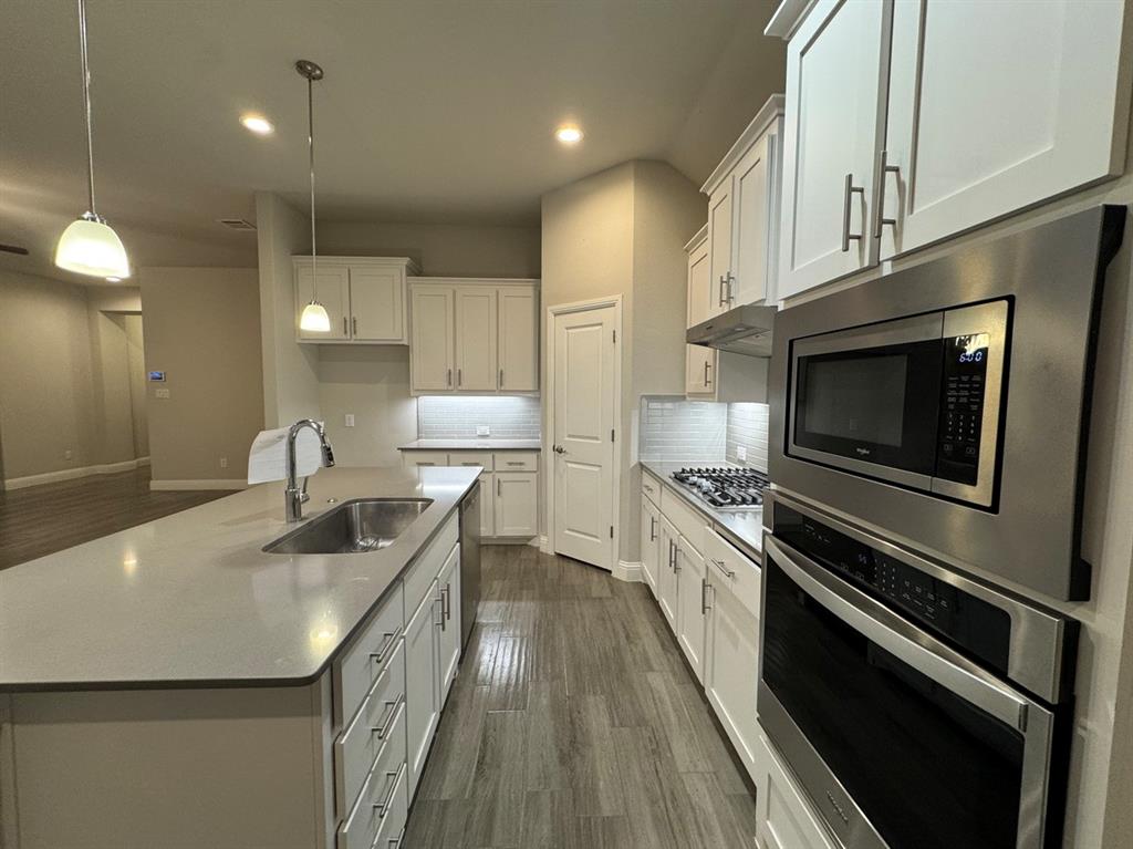 3432 Cornerstone Lane Midlothian, TX 76065 - Photo 19 of 40 a kitchen with stainless steel appliances sink stove microwave and cabinets