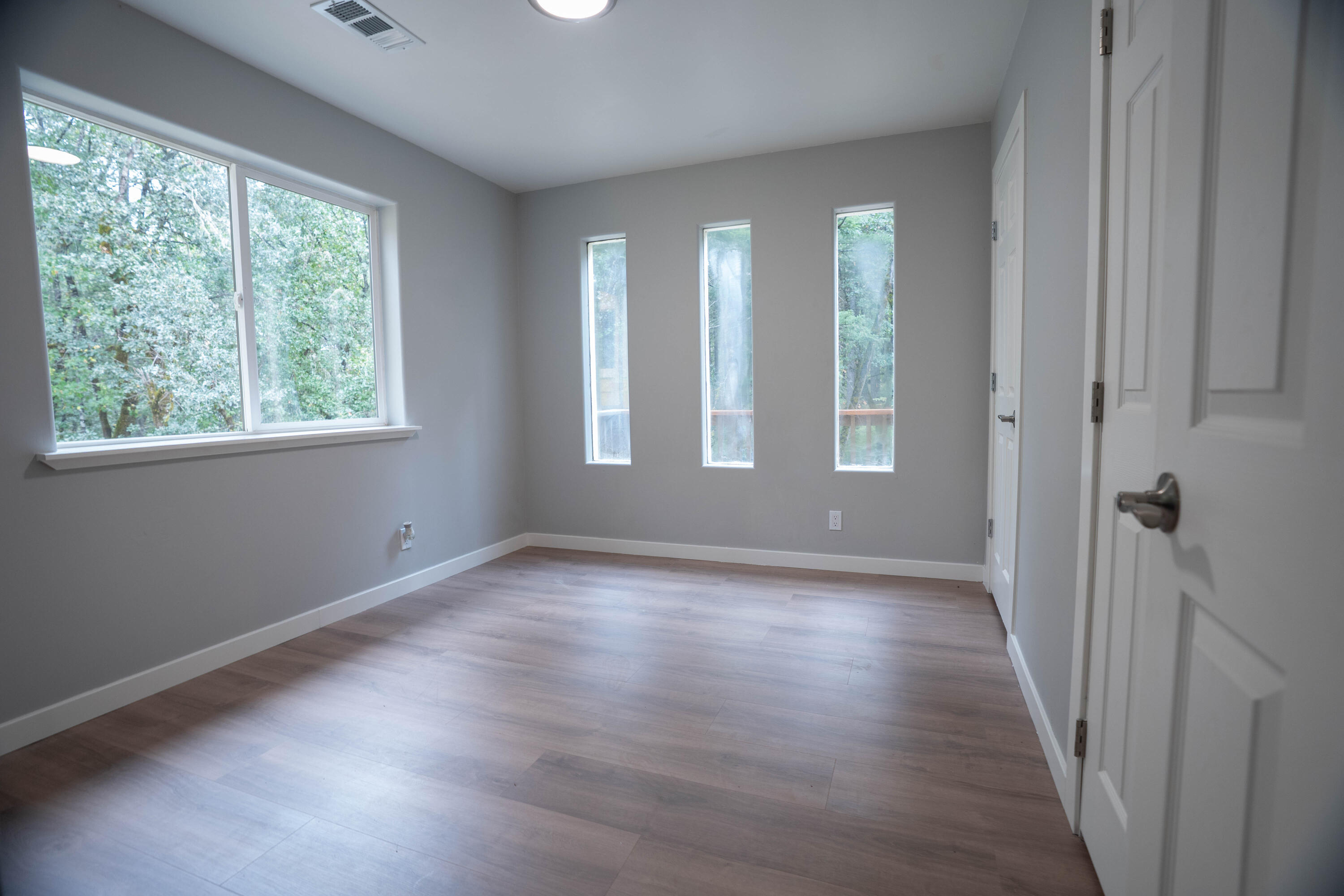 709 Pinewood Way Cave Junction, OR 97523 - Photo 17 of 24 a view of an empty room with wooden floor and a window