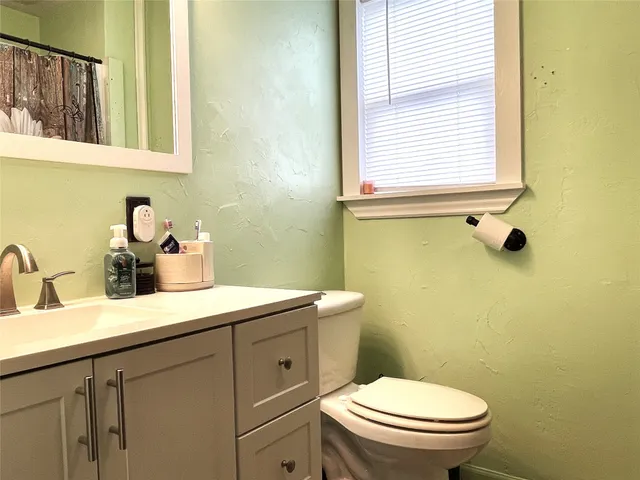 a bathroom with a sink a toilet and a mirror
