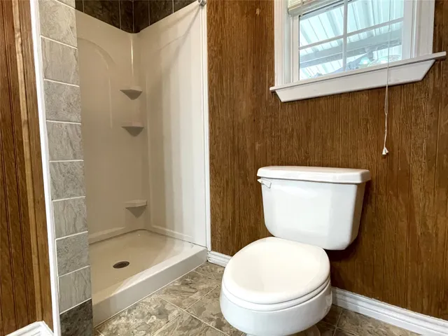 a bathroom with a toilet and a shower