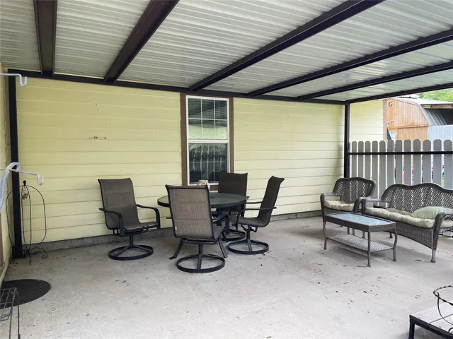 a view of a patio with table and chairs and wooden floor