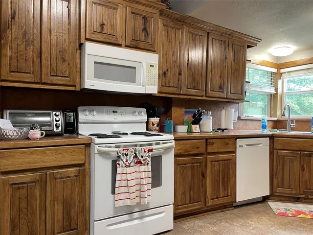 a kitchen with granite countertop cabinets stainless steel appliances and a sink