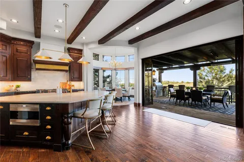 a kitchen with stainless steel appliances granite countertop a sink a stove and a wooden floors