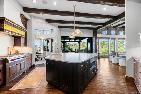 a large kitchen with kitchen island a large island a sink and a large window