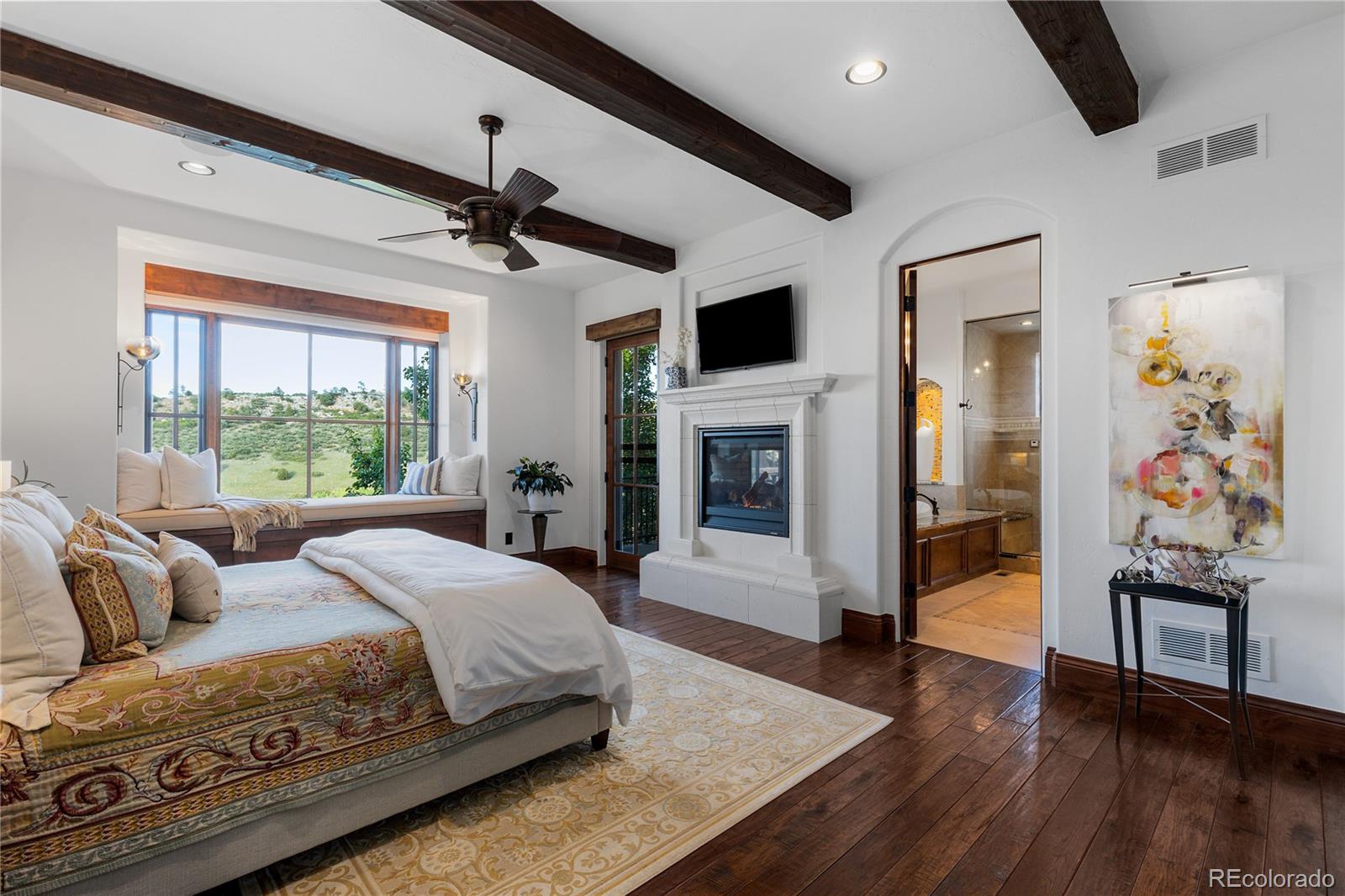7208 Raphael Lane Littleton, CO 80125 - Photo 20 of 47 a spacious bedroom with a balcony a bed and a flat screen tv