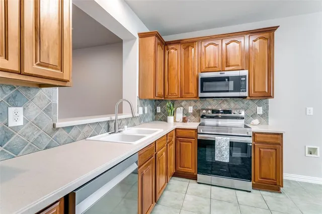a kitchen with stainless steel appliances granite countertop a sink and dishwasher a stove top oven with wooden floor