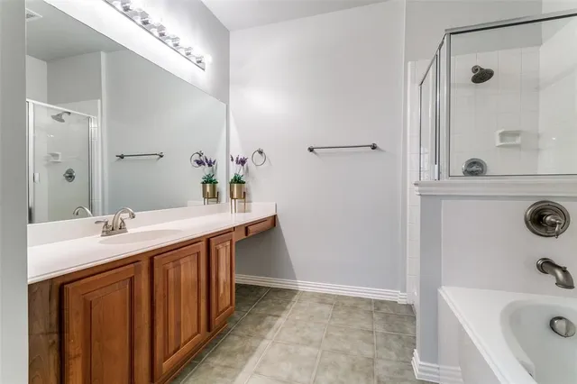 a bathroom with a sink double vanity granite tub shower and mirror