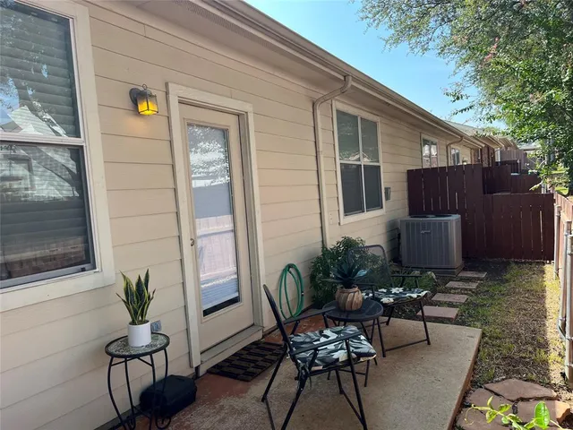 a view of a chair and table in back yard of the house