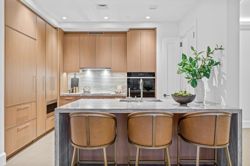 40 Trinity Place, Unit PH34D Boston, MA 02116 - Photo 5 of 37 a kitchen with stainless steel appliances granite countertop a table chairs and a refrigerator