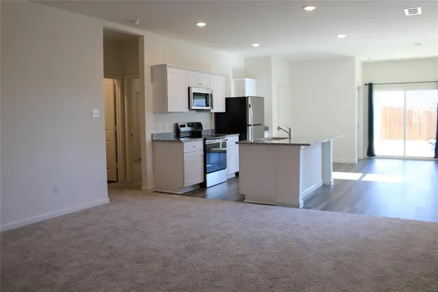 a kitchen with stainless steel appliances a refrigerator and a stove top oven