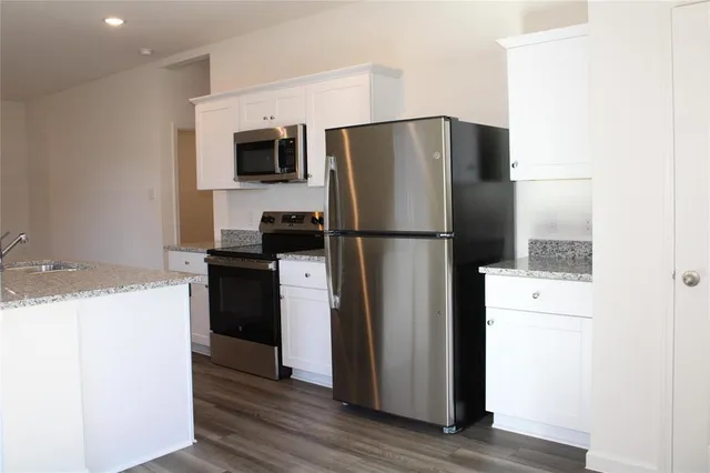 a kitchen with a refrigerator a stove and a microwave
