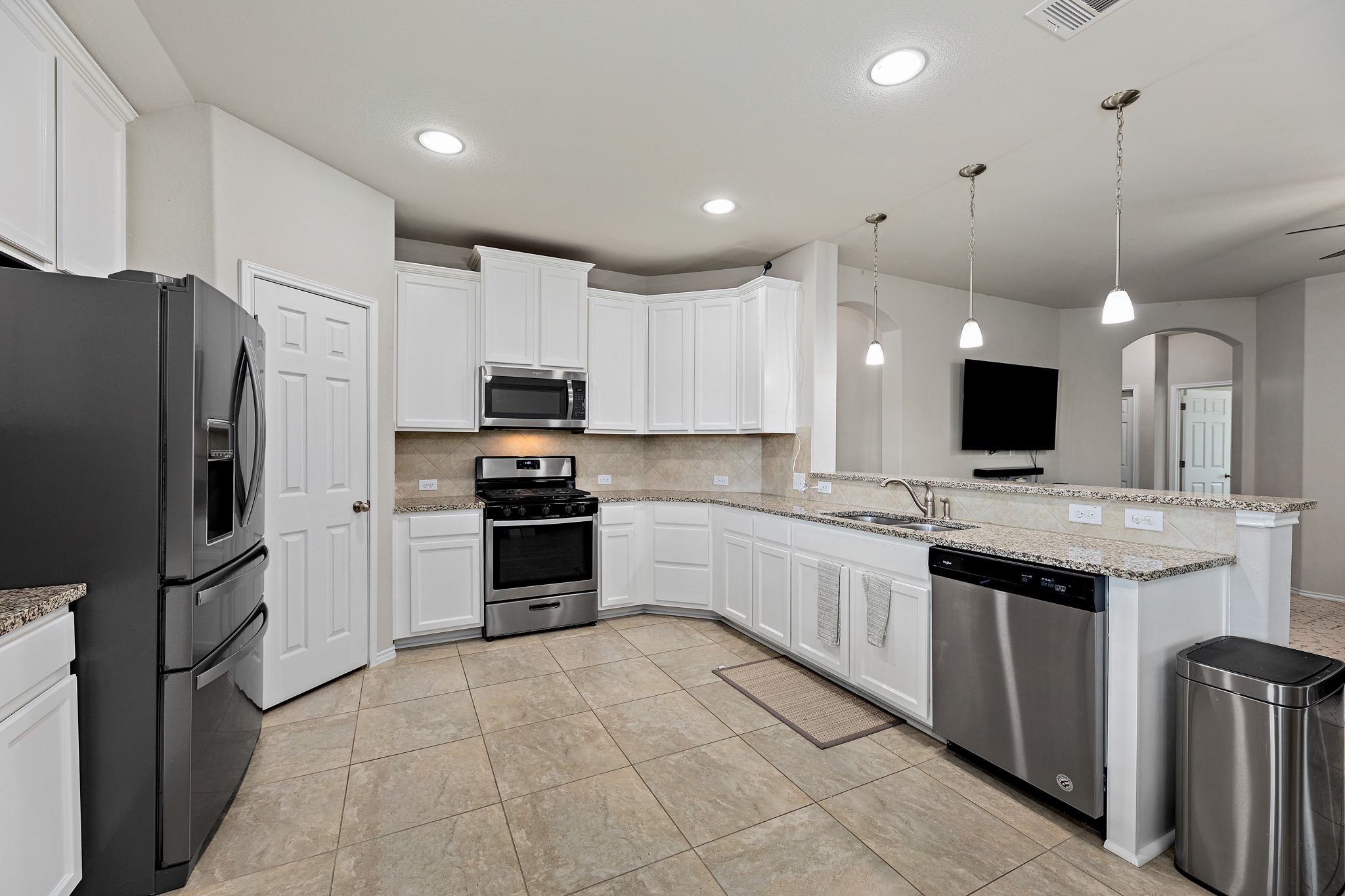 382 Limerick Road Buda, TX 78610 - Photo 5 of 20 Culinary adventures await in this kitchen, boasting white cabinetry and granite countertops.