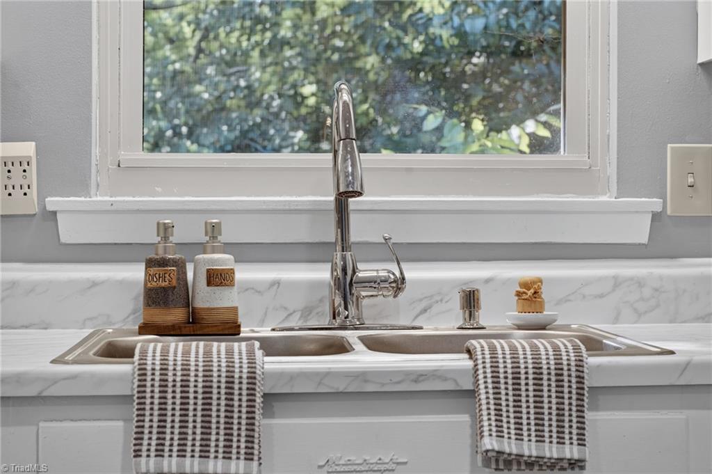113 Green Valley Road Greensboro, NC 27403 - Photo 16 of 46 A kitchen sink with a view—because even everyday moments are better with natural light and mature landscaping outside your window.