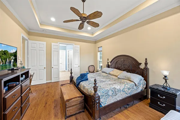 a bedroom with bed and wooden floor