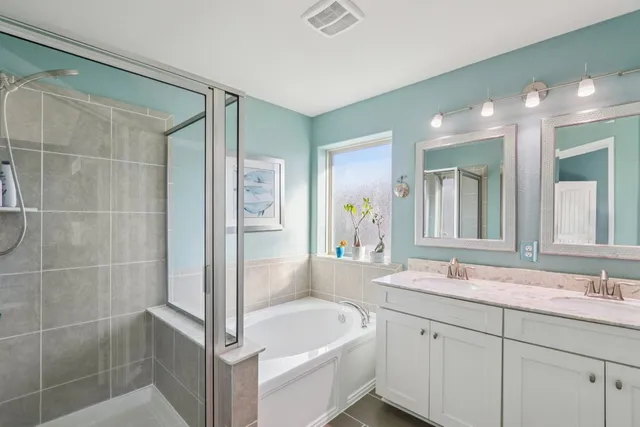 a bathroom with a tub sink and mirror