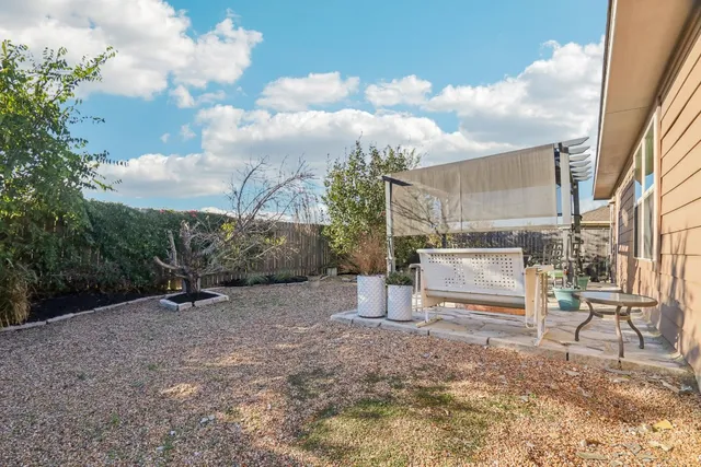 a backyard of a house with table and chairs