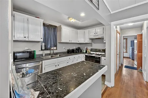 a kitchen with stainless steel appliances granite countertop a refrigerator and a stove top oven