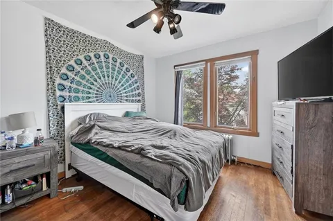 a bedroom with a bed and a flat tv screen on dresser