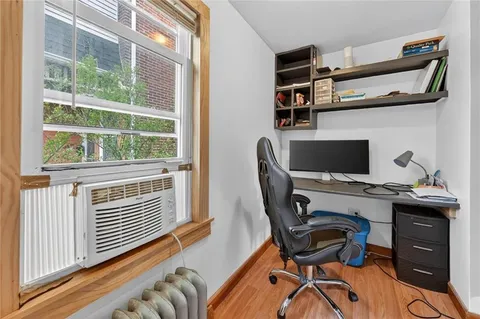 a view of a workspace with furniture and a window