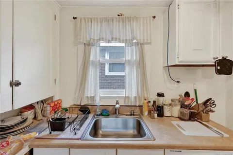 a kitchen with white cabinets and sink