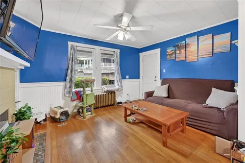 a living room with furniture a chandelier and a wooden floor