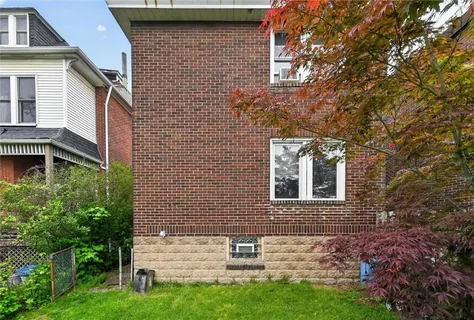 a brick house with a small yard and front a house