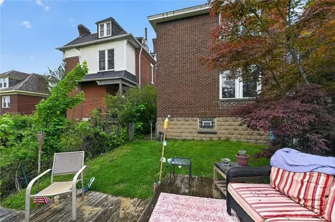 a backyard of a house with table and chairs