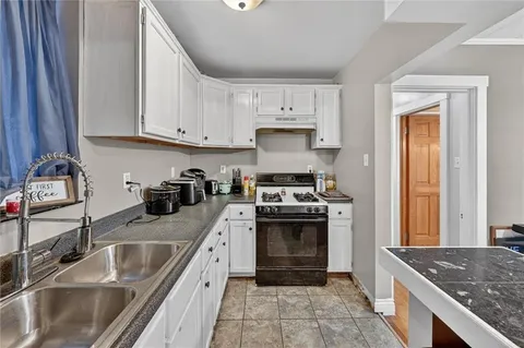 a kitchen with granite countertop a sink stainless steel appliances and cabinets