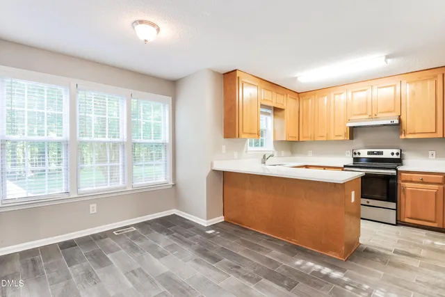 a kitchen with stainless steel appliances granite countertop a stove a sink and a refrigerator