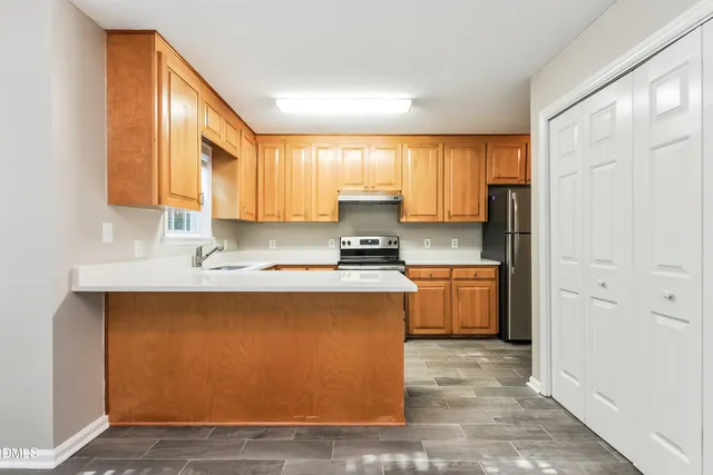 a kitchen with stainless steel appliances granite countertop a stove a sink and a refrigerator