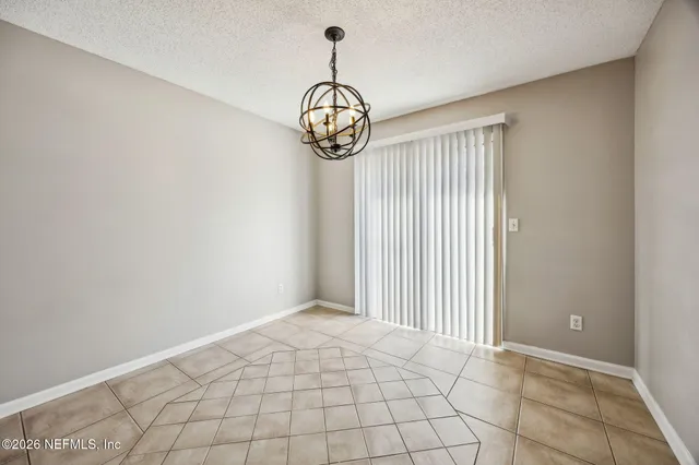 an empty room with windows and ceiling fan